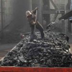 A labourer loads coal onto a truck at Sanyuan Coal Mine in Changzhi, Shanxi province, China